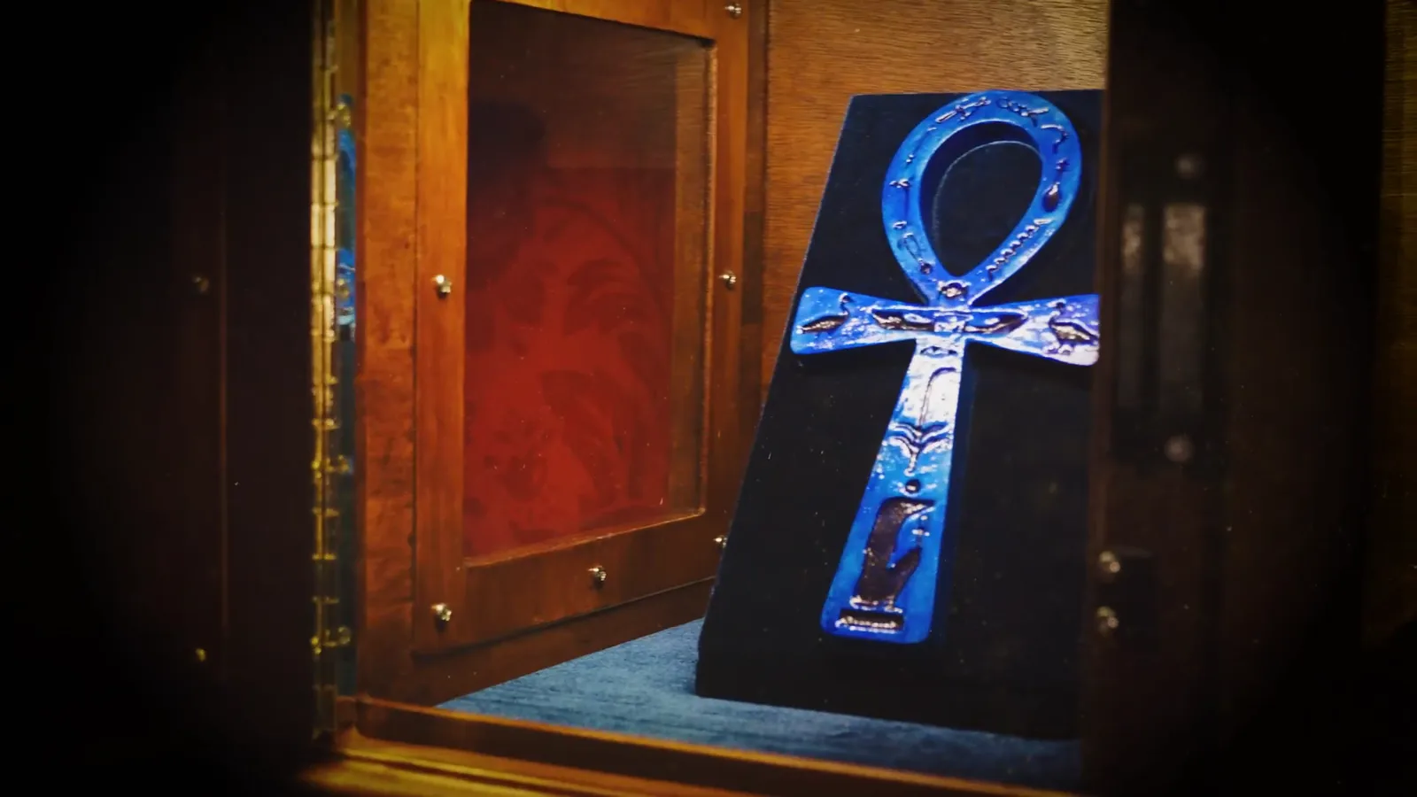 A glowing blue ankh in a display case in Entombed